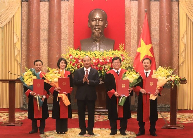 Chủ tịch nước Nguyễn Xuân Phúc trao quyết định bổ nhiệm và tặng hoa chúc mừng 4 tân thẩm phán TAND Tối cao. Ảnh: H. Vũ.