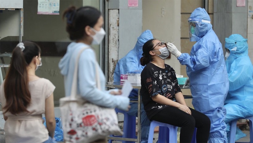Nhân viên y tế lấy mẫu cho người dân bên ngoài cổng Bệnh viện Việt Đức.