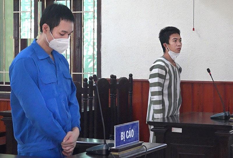 Bị cáo Đinh Quốc Tuấn (áo xanh) và đàn em Nguyễn Anh Quốc đối chứng tại phiên tòa.