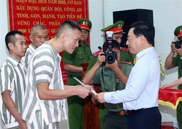 Phó Thủ tướng Thường trực Chính phủ Phạm Bình Minh trao quyết định đặc xá cho các phạm nhân. Ảnh: Phạm Kiên/TTXVN.