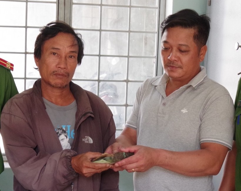 Anh Kiệt (bên trái) trao trả lại số tiền cho gia đình người đánh mất.