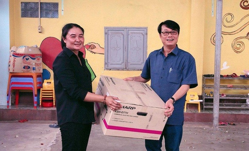 Thầy Lê Đắc Tường (bên phải) tặng quà cho Cô nhi viện Vinh Sơn 4.