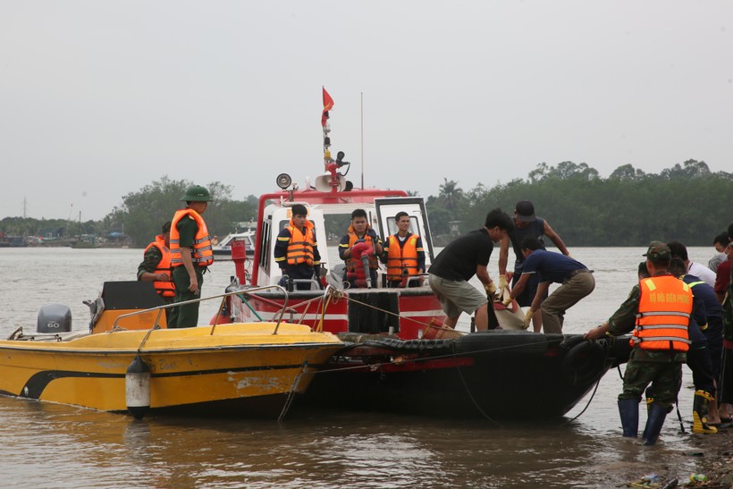 Lực lượng tìm kiếm cứu nạn đưa thi thể nạn nhân được tìm thấy lên bờ.