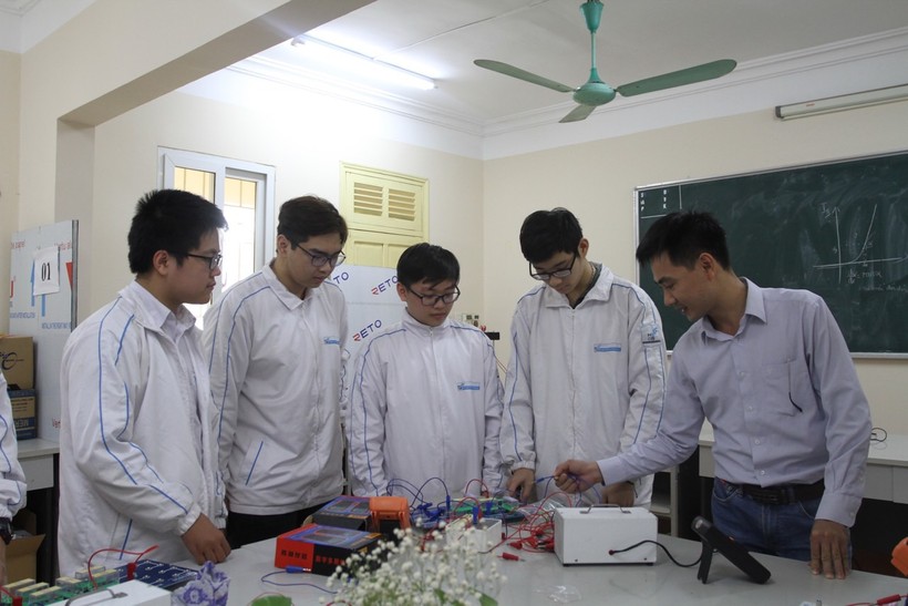 Lê Minh Hoàng (đứng giữa) cùng thầy giáo và các bạn Trường THPT chuyên Khoa học Tự nhiên trong giờ thực hành Vật lý