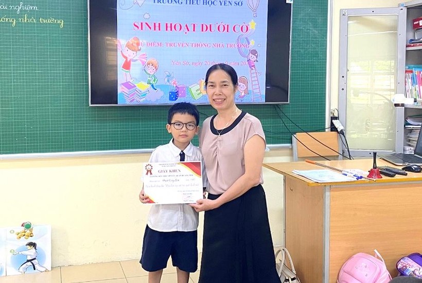 Cô giáo Nguyễn Thị Hồng - Hiệu trưởng trường Tiểu học Yên Sở tặng giấy khen cho em Phạm Tùng Lâm vì hành động đẹp.