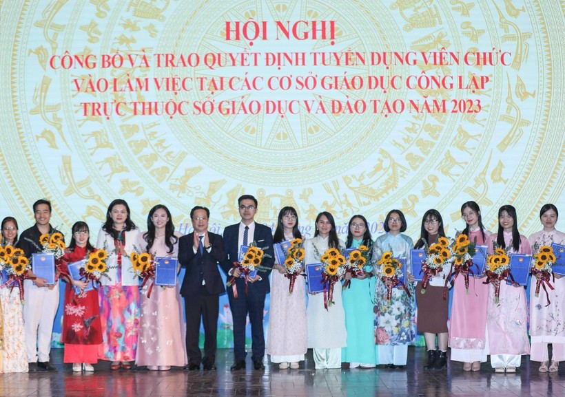Lãnh đạo Sở GD&ĐT Hà Nội trao quyết định tuyển dụng và tặng hoa cho các giáo viên.