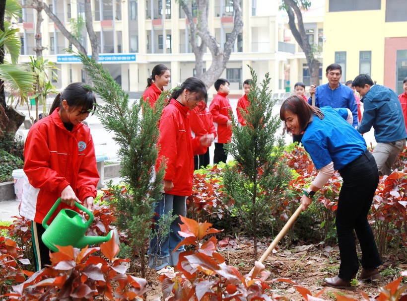 Giáo viên và học sinh Trường Tiểu học Mê Linh (huyện Mê Linh, Hà Nội) trồng cây trong sân trường.