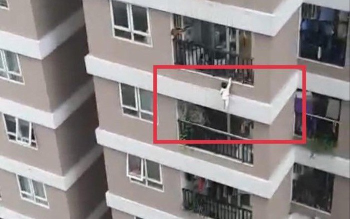 Hình ảnh bé gái lơ lửng trên lan can tầng 13 chung cư 60B Nguyễn Huy Tưởng. Ảnh cắt từ clip