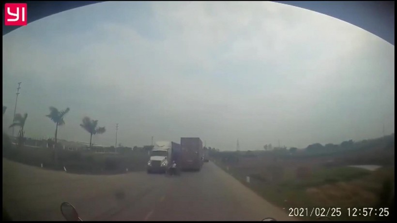 Cô gái sang đường ẩu khiến tài xế xe container phải phanh gấp, đánh lái để tránh. Ảnh cắt từ clip