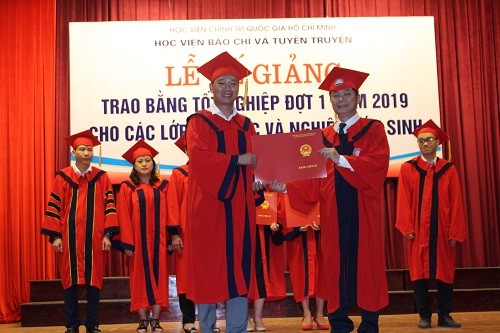 PGS, TS Phạm Minh Sơn, Phó Giám đốc Học viện Báo chí và Tuyên truyền  trao bằng Tiến sĩ cho các nghiên cứu sinh tốt nghiệp.