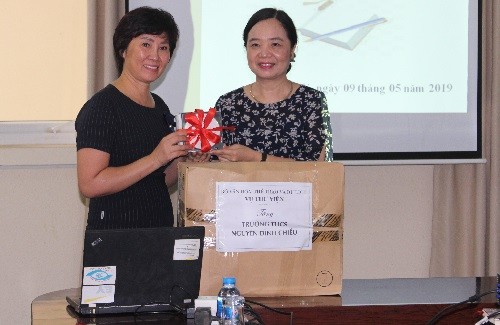 Vụ trưởng Vụ thư viện Vũ Dương Thúy Ngà (bên phải) tặng sách cho đại diện Trường PTCS Nguyễn Đình Chiểu, cô hiệu trưởng Phạm Thị Kim Nga