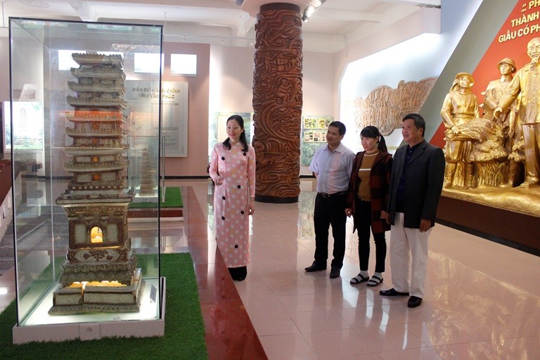 Thuyết minh viên Bảo tàng tỉnh hướng dẫn khách tham quan tìm hiểu về giá trị của tháp gốm men chùa Trò. Ảnh: Kim Ly