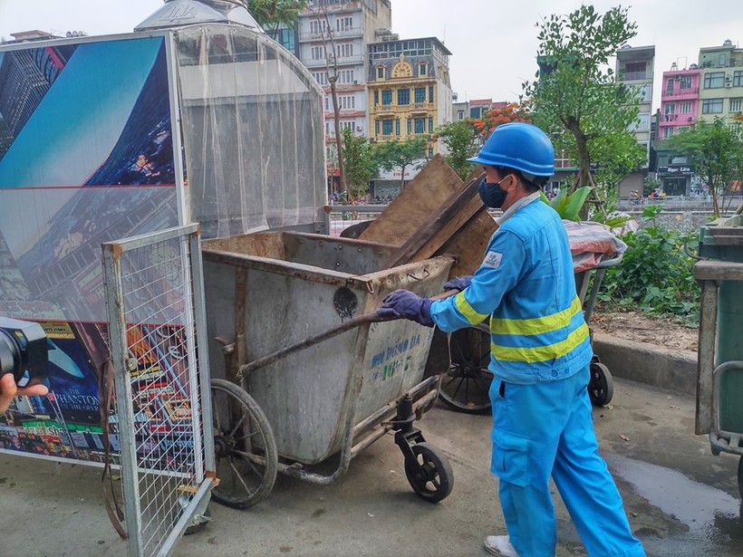 Công nhân đang đẩy xe rác vào “nhà ở di động”.