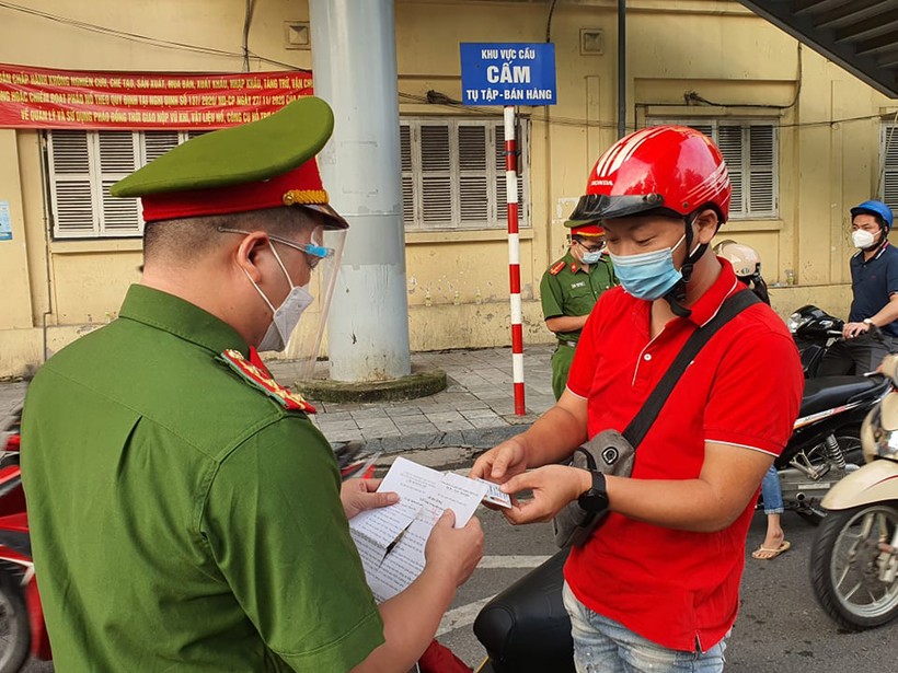 Lực lượng chức năng kiểm tra giấy đi đường tại chốt phòng dịch.