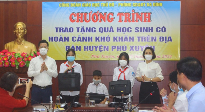 Trưởng phòng GD&ĐT quận Ba Đình Lê Đức Thuận (bên trái ngoài cùng) trao tặng máy tính cho học sinh khó khăn huyện Phú Xuyên.