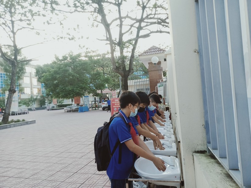 Học sinh trường THCS Hoàng Ninh bên những bồn rửa tay với xà phòng và nước sạch.