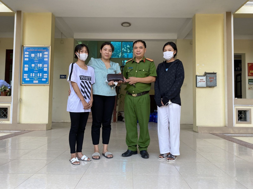 Đại diện công an xã Song Khê cùng hai em học sinh trao trả lại hiện vật cho người bị mất. 