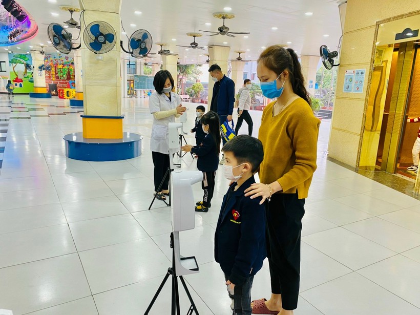 Trường Mầm non Sao Mai (thành phố Bắc Ninh) thực hiện đo thân nhiệt cho học sinh trước khi vào trường.