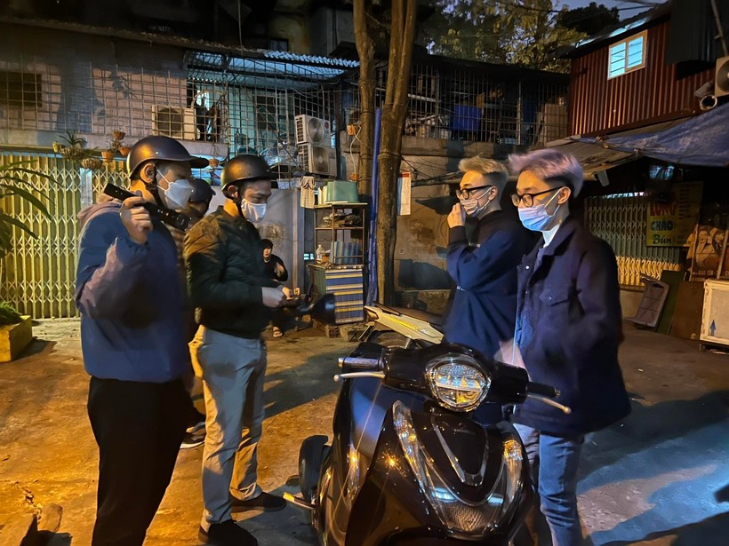 Lực lượng cảnh sát (bên phải cầm đèn) kiểm tra, xử lý nhóm thanh niên gây mất an ninh trật tự trong đêm.  