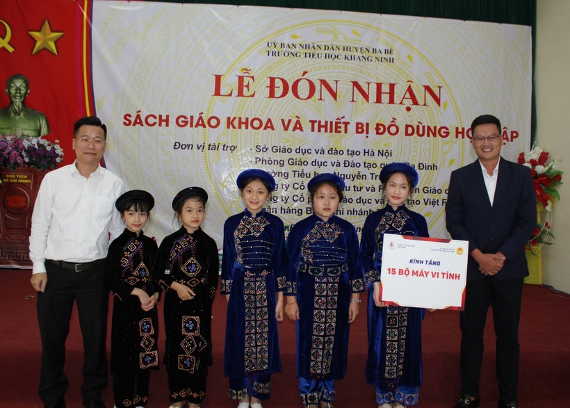 Ông Lê Đức Thuận - Trưởng phòng GD&ĐT quận Ba Đình (bên trái) cùng nhà tài trợ trao sách giáo khoa cho học sinh.