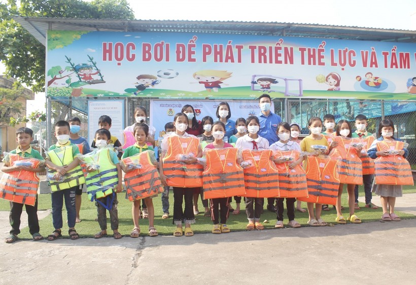 Lãnh đạo Huyện đoàn cùng Ban giám hiệu trường Tiểu học Tân Hưng gửi tặng áo phao và kính bơi của nhà tài trợ cho các em học sinh.