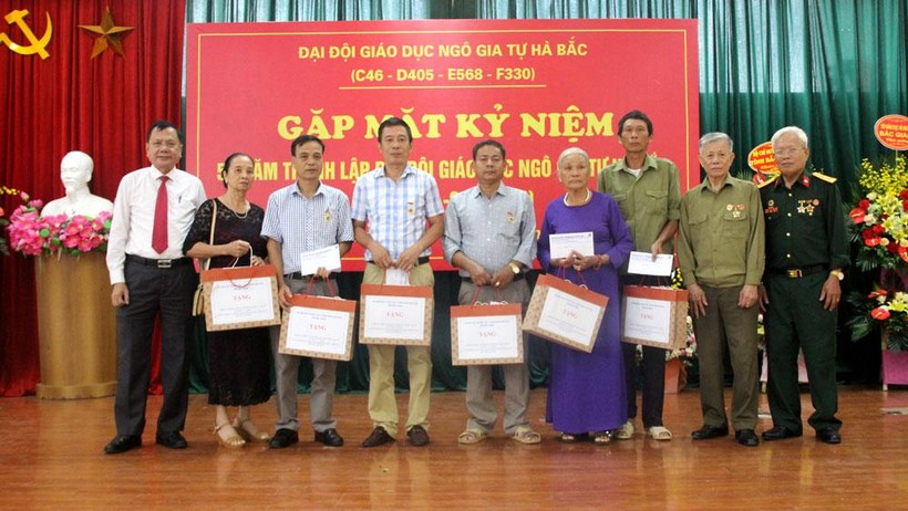 Ông Nguyễn Văn Thêm – Phó Giám đốc Sở GD&ĐT (ngoài cùng bên trái) thay mặt ngành Giáo dục tặng quà cho đại diện gia đình các liệt sĩ (Ảnh Minh Thu).