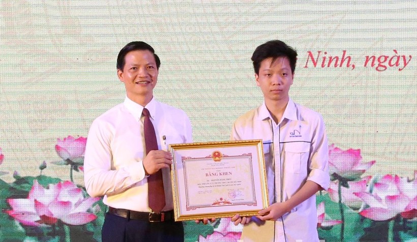 Phó Chủ tịch Thường trực UBND tỉnh Bắc Ninh Vương Quốc Tuấn trao Bằng khen cho em Nguyễn Đăng Phúc.
