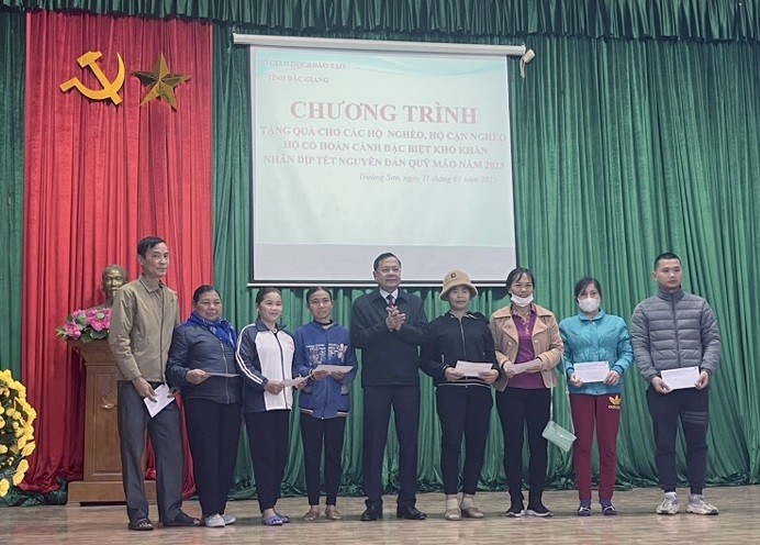 Ông Nguyễn Văn Thêm - Phó Giám đốc Sở GD&ĐT tặng quà cho đại diện các hộ gia đình chính sách, hộ nghèo trên địa bàn xã Trường Sơn.