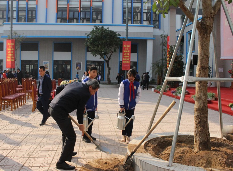 Bí thư Quận ủy Ba Đình - Hoàng Minh Dũng Tiến cùng học sinh trường THCS Thành Công trồng cây tại lễ phát động.