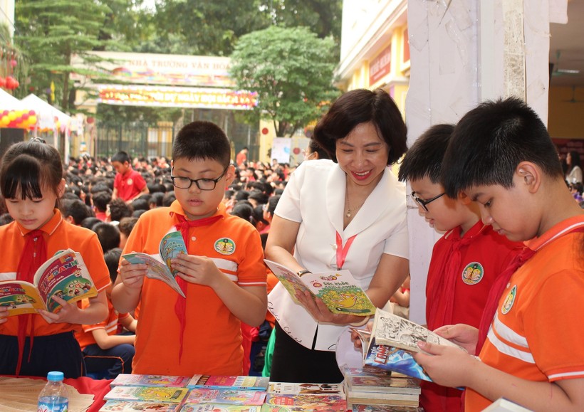 Nhà giáo Trần Thị Bích Liên - Hiệu trưởng trường Tiểu học CLC Tràng An và học trò cùng đọc sách trong ngày hội.