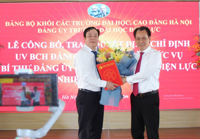 Ông Nguyễn Thanh Sơn - Bí thư Đảng ủy Khối các trường ĐH CĐ Hà Nội (bên phải) trao quyết định và chúc mừng tân Bí thư Đảng ủy trường Đại học Điện lực.