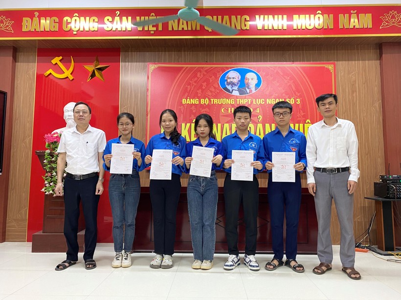 Thầy Phạm Hồng Dương - Bí thư Đảng bộ, Hiệu trưởng Trường THPT Lục Ngạn số 3 (ngoài cùng bên trái) và Bí thư Chi bộ 4 trao Quyết định kết nạp đảng viên mới cho 5 học sinh.