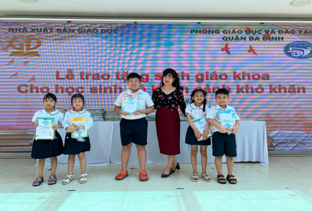 Cô Phạm Thị Thiên Nga - Hiệu trưởng trường Tiểu học Nguyễn Bá Ngọc cùng một số học sinh nhận sách giáo khoa mới.