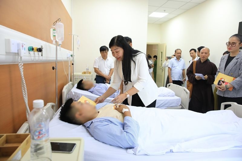 Chủ tịch Ủy ban MTTQ Việt Nam TP Nguyễn Lan Hương thăm nạn nhân đang điều trị tại bệnh viện.