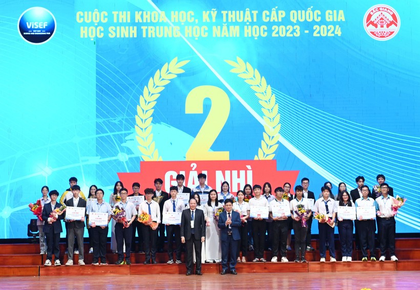 Ông Nguyễn Xuân Thành - Vụ trưởng Vụ Giáo dục Trung học Bộ GD&ĐT (bên phải) và ông Tạ Việt Hùng - Giám đốc Sở GD&ĐT Bắc Giang tặng hoa và trao giải Nhì.