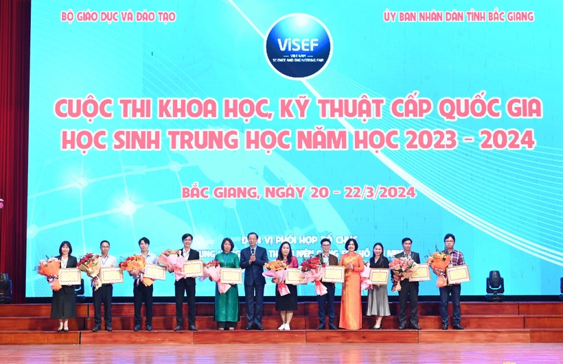 Thứ trưởng Bộ GD&amp;ĐT Phạm Ngọc Thưởng và bà Lê Thị Mai Oanh tặng Bằng khen Công đoàn Giáo dục Việt Nam và hoa chúc mừng 10 giáo viên bồi dưỡng học sinh có dự án đạt giải Nhất.