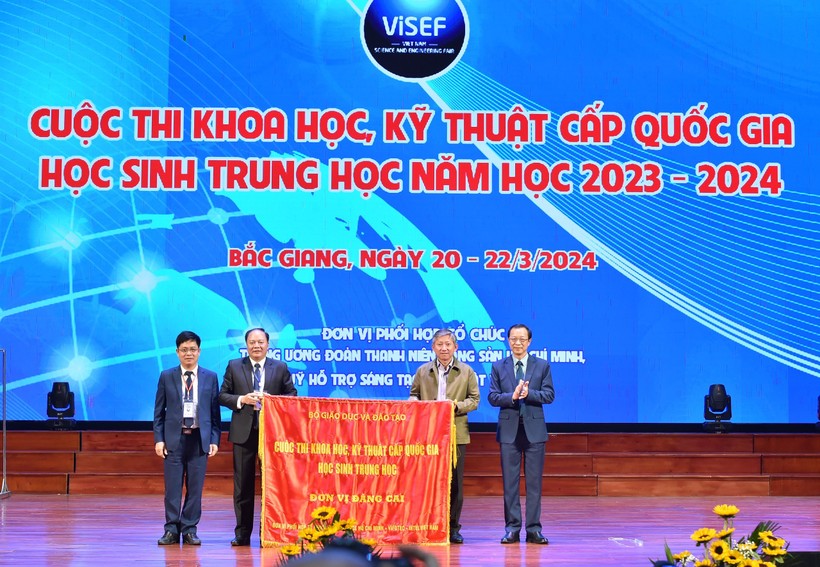 Lãnh đạo Sở GD&ĐT Bắc Giang (bên trái) trao cờ cho lãnh đạo Sở GD&ĐT TP Hồ Chí Minh, đơn vị đăng cai năm tiếp theo.
