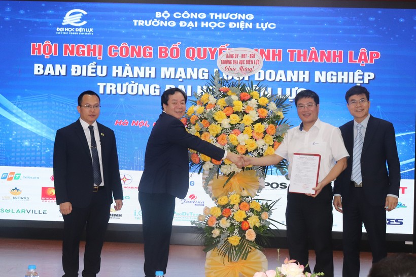 PGS.TS Vũ Đình Ngọ (thứ 2 từ trái sang) tặng hoa chúc mừng lãnh đạo Ban điều hàng mạng lưới doanh nghiệp của nhà trường. 