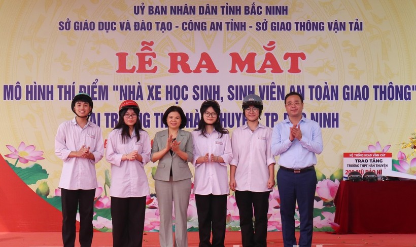 Chủ tịch UBND tỉnh Bắc Ninh - Nguyễn Hương Giang và Giám đốc Sở GDĐT Bắc Ninh Nguyễn Thế Sơn trao mũ bảo hiểm cho học sinh.