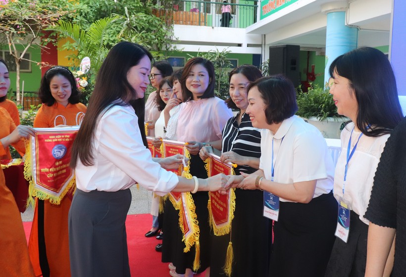 Bà Phạm Thị Diễm - Phó Chủ tịch UBND quận Ba Đình (bên trái) trao cờ thi đua cho đại diện các đơn vị tham dự Hội thi.