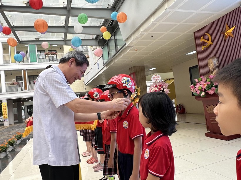 Bí thư Quận uỷ Ba Đình, Hoàng Minh Dũng Tiến đội mũ bảo hiểm cho học sinh trường Tiểu học Kim Đồng.