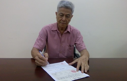 Nhà giáo Lưu Đức Ngò xem lại phiếu thu của UBND thị trấn Bần Yên Nhân và UBND xã Nghĩa Hiệp về việc tặng quà thương binh, thân nhân liệt sỹ.