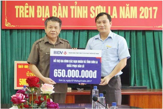 Đồng chí Lò Mai Kiên, Ủy viên BTV tỉnh ủy, Chủ tịch Ủy ban MTTQ Việt Nam tỉnh Sơn La tiếp nhận tiền hỗ trợ của BIDV