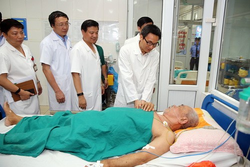 Phó Thủ tướng Vũ Đức Đam hỏi thăm một bệnh nhân cao tuổi mắc SXH đang điều trị tại Bệnh viện Nhiệt đới Trung ương. Ảnh: VGP