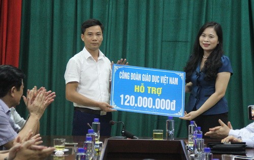 Phó Chủ tịch Công đoàn Giáo dục Việt Nam Nguyễn Thị Bích Hợp trao tiền hỗ trợ cho cán bộ, gáo viên huyện Mai Sơn (Sơn La) bị mất nhà do mưa lũ