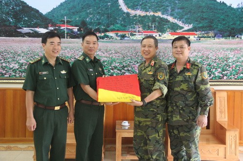 Thay mặt  cán bộ, chiến sỹ Đồn Biên phòng Lũng Cú, Trung tá Nguyễn Hồng Phong (thứ hai từ trái qua phải) đã tặng Đoàn công tác lá Quốc kỳ rộng 54m2.
