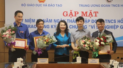 Thứ trưởng Nguyễn Thị Nghĩa trao Kỷ niệm chương "Vì sự nghiệp GD" và tặng hoa chúc mừng 4 đồng chí được trao Kỷ niệm chương. Ảnh: Sỹ Điền