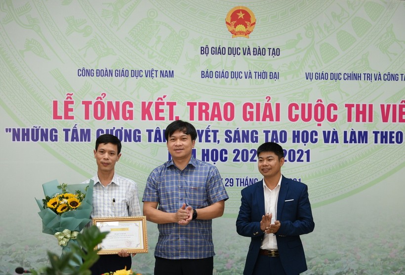 Ông Doãn Hồng Hà (ở giữa) chúc mừng tác giả Trần Tuấn Ngọc (ngoài cùng bên phải) và trao phần thưởng cho thầy giáo Vũ Xuân Quế - Hiệu trưởng Trường THCS và THPT Bát Xát (Lào Cai) - nhân vật trong tác phẩm “Người thầy mang bếp lửa đến vùng cao”.