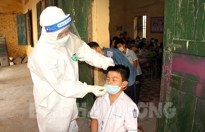 Ban chỉ đạo Phòng chống dịch bệnh Covid-19 huyện Ninh Giang lấy mẫu xét nghiệm cho học sinh Trường Tiểu học Kiến Quốc. Ảnh: Báo Hải Dương