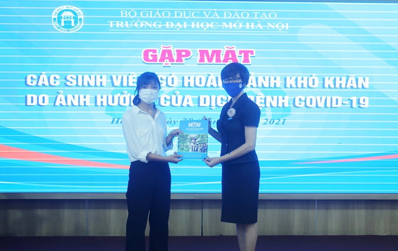 Sinh viên nhận quà hỗ trợ của Trường ĐH Mở Hà Nội từ Phó Hiệu trưởng Nguyễn Minh Phương. Ảnh: NTCC